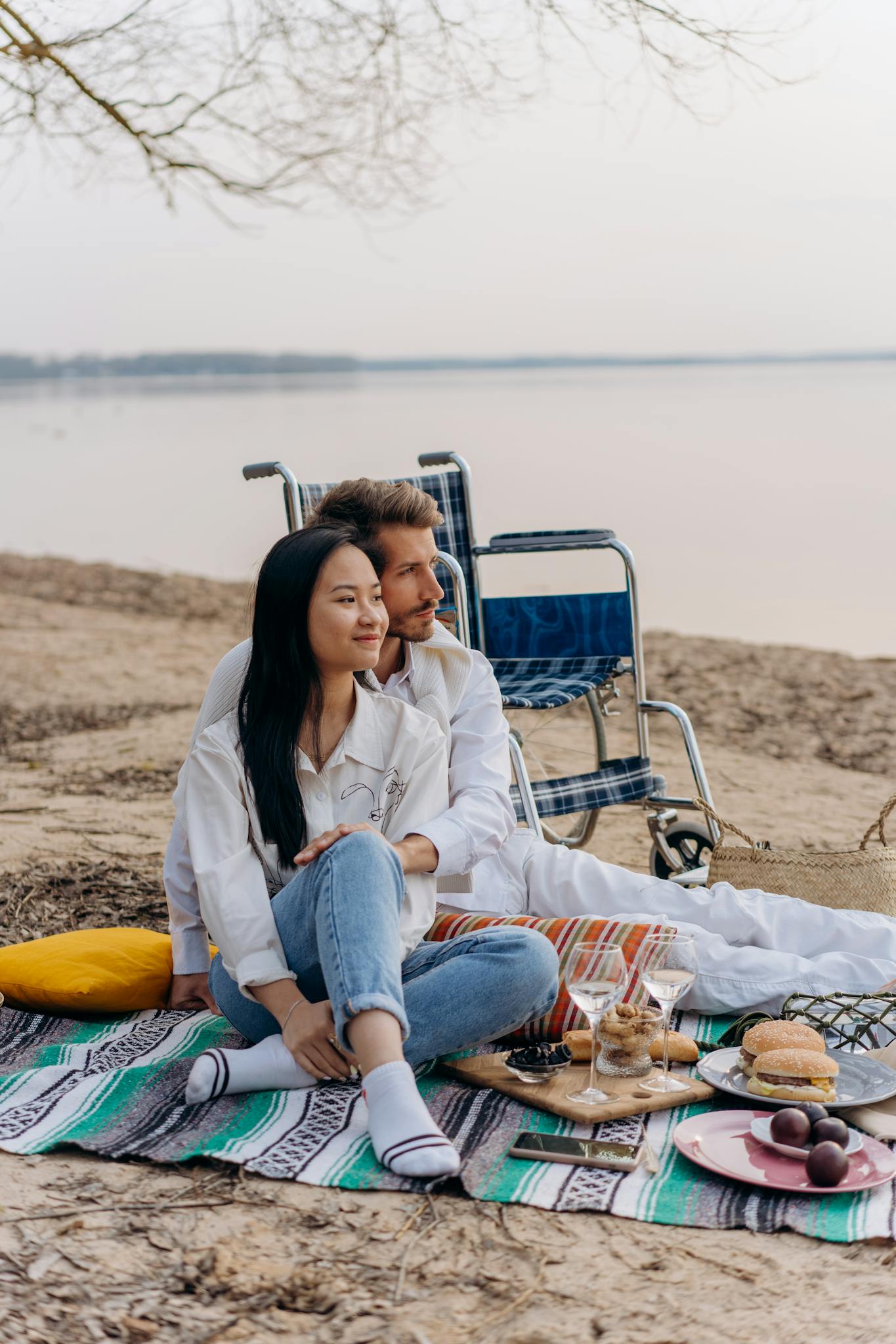 Couple enjoying a romantic picnic by the beach with wheelchair accessibility.