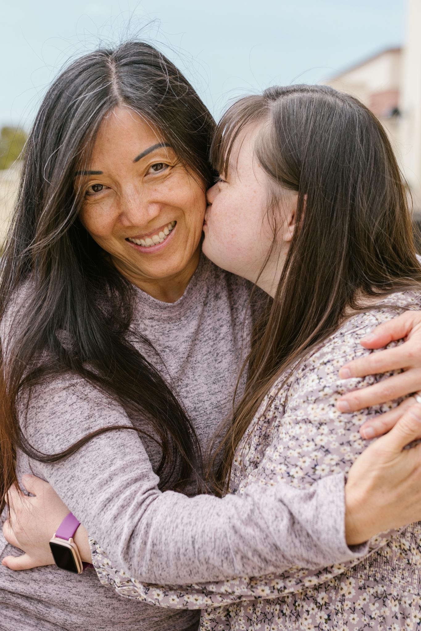 Smiling mother and daughter embracing with affection and closeness.